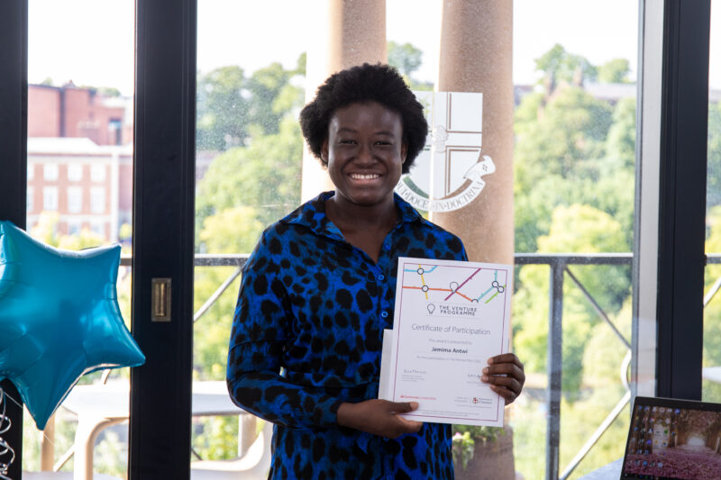 Jemma Antwi is smiling and holding a certificate of participation.